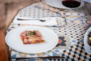 Coca de dacsa con pimientos y berenjena asada, sardina ahumada y panceta